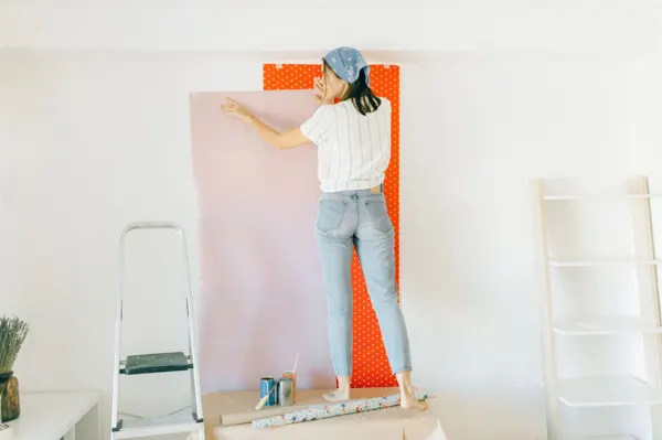 Persona colocando papel en una pared